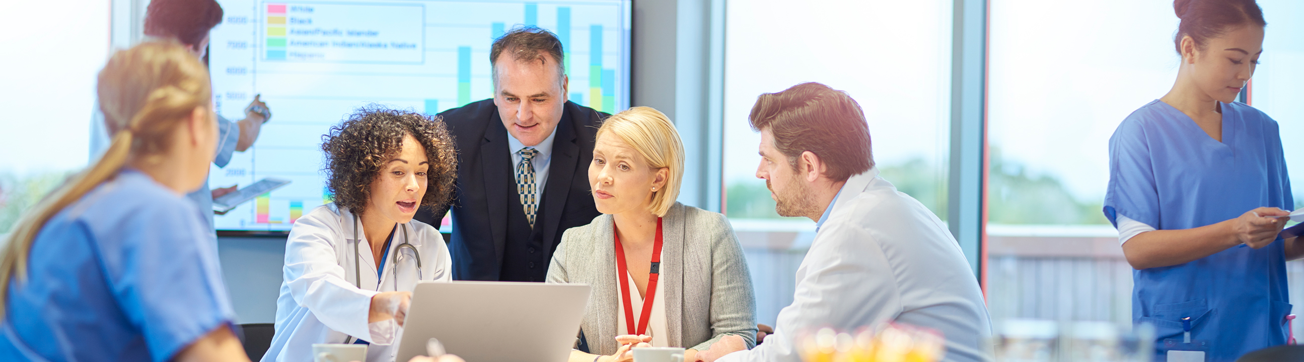 A heath care provider team is reviewing a digital report and actively collaborating. 